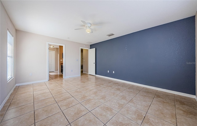 tiled empty room with ceiling fan