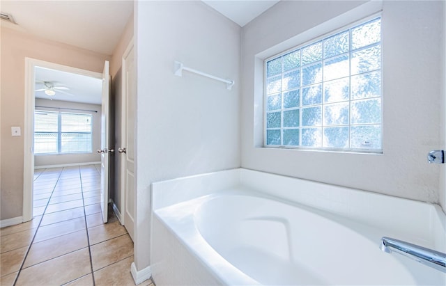 bathroom with tile patterned flooring and a relaxing tiled tub