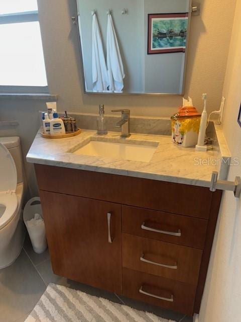 bathroom with vanity, tile patterned floors, and toilet