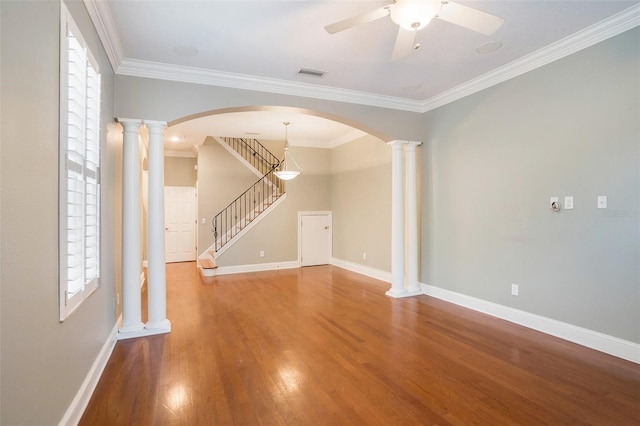 unfurnished living room featuring wood finished floors, visible vents, ornate columns, and baseboards