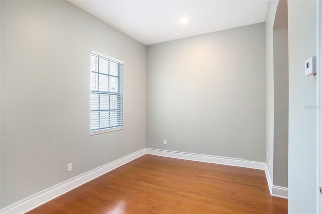 spare room featuring baseboards and wood finished floors