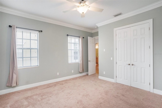 unfurnished bedroom with visible vents, baseboards, ornamental molding, light carpet, and a closet