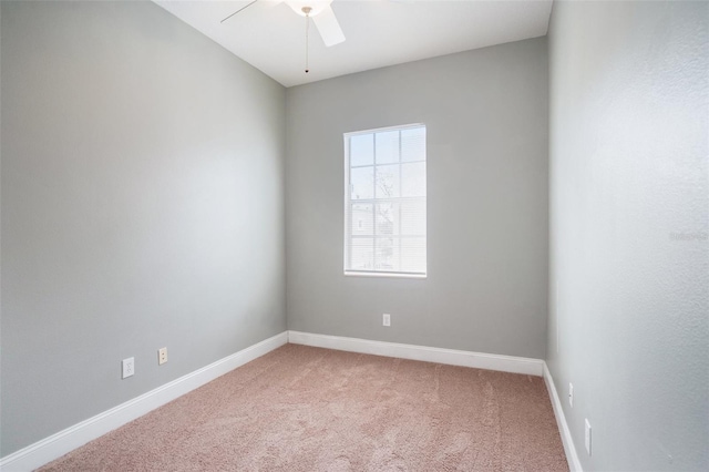 empty room featuring ceiling fan, baseboards, and light carpet