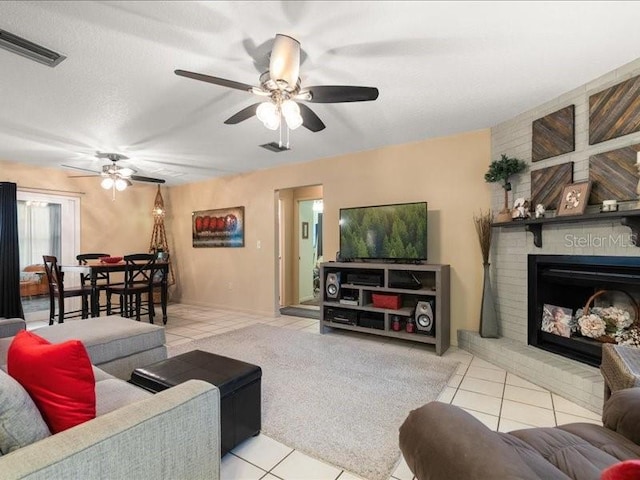 tiled living room with a fireplace and ceiling fan