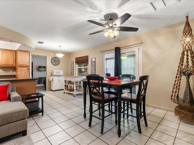 dining area with light tile patterned flooring and ceiling fan