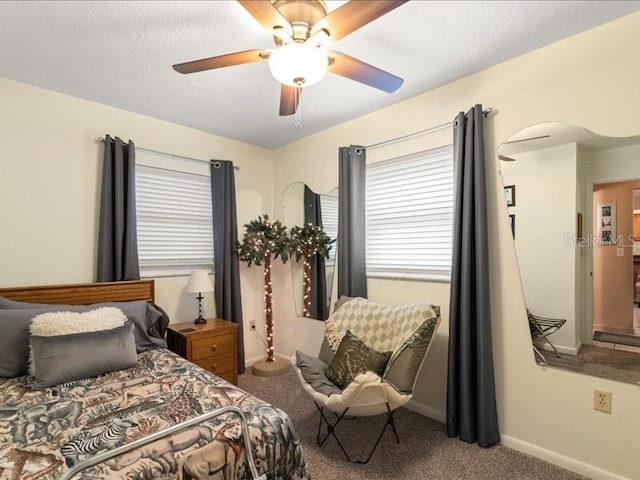 bedroom with ceiling fan, carpet flooring, and a textured ceiling