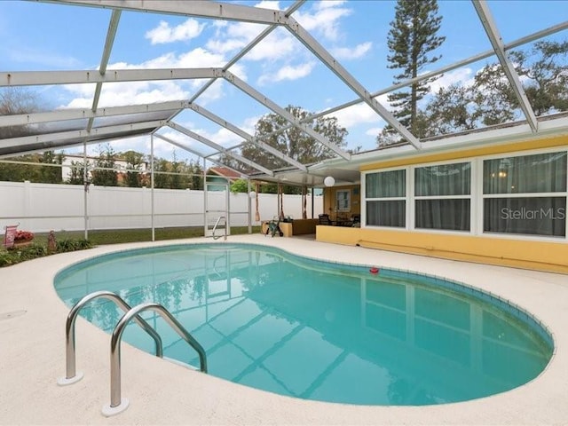 view of pool with a patio area and glass enclosure