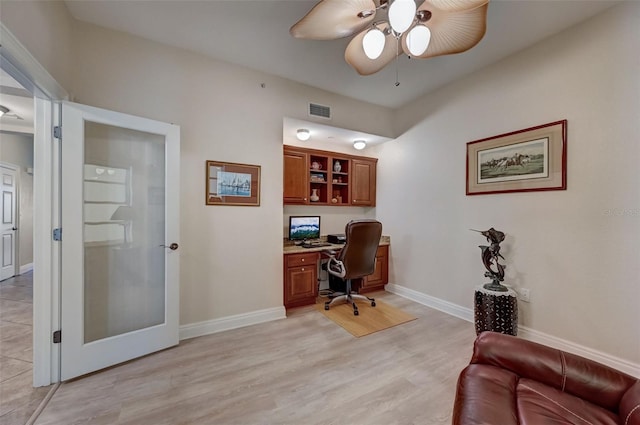 office featuring ceiling fan, built in desk, and light hardwood / wood-style floors