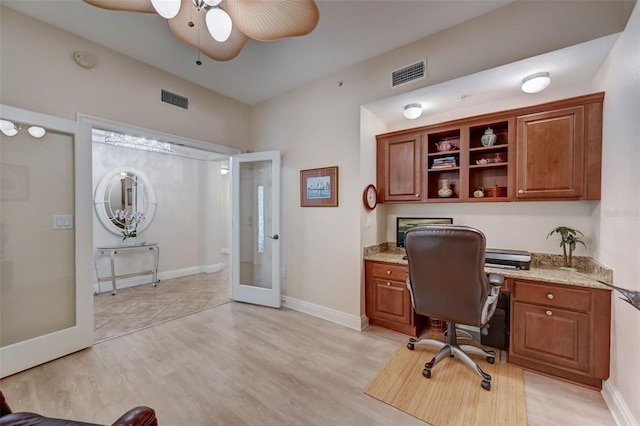 office space with french doors, ceiling fan, built in desk, and light hardwood / wood-style flooring