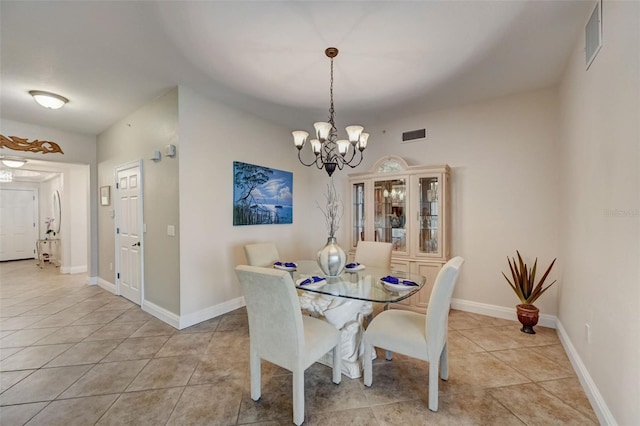 dining room with light tile patterned floors and a notable chandelier