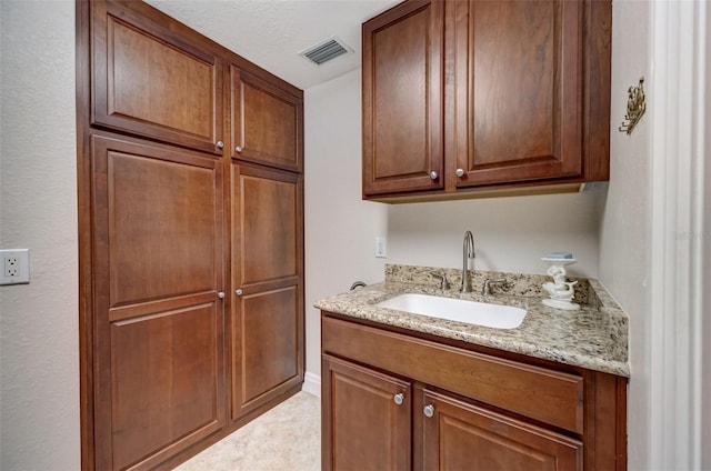 kitchen featuring light stone countertops and sink