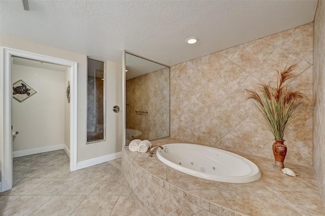 bathroom featuring tiled tub, tile patterned flooring, and a textured ceiling