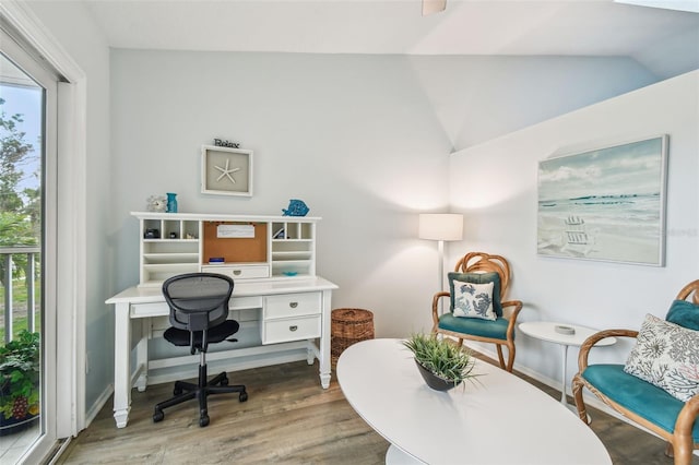 office space with vaulted ceiling, a healthy amount of sunlight, and hardwood / wood-style floors