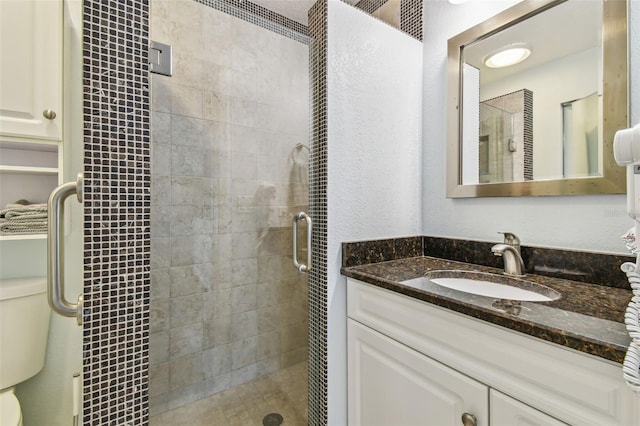 bathroom with vanity, toilet, and a shower with door