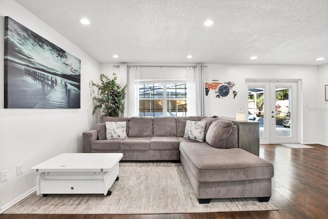 living room featuring hardwood / wood-style floors, a textured ceiling, and french doors