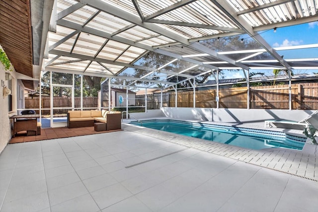 view of pool with a storage shed, a patio, glass enclosure, an outdoor living space, and a hot tub