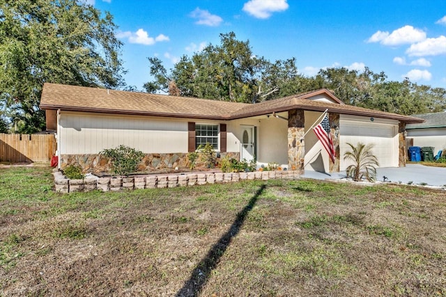 ranch-style home featuring a garage and a front lawn