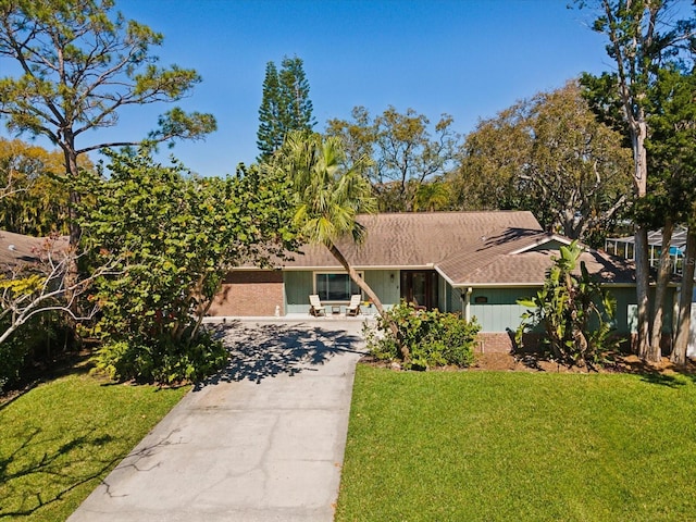 view of front of house featuring concrete driveway and a front yard