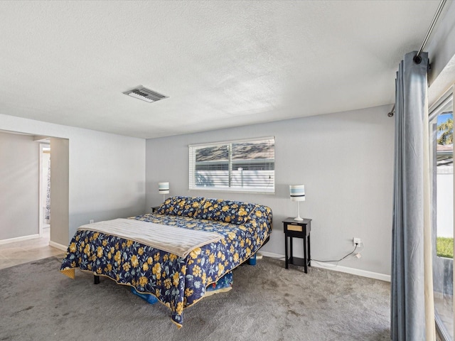 carpeted bedroom with baseboards, visible vents, and a textured ceiling