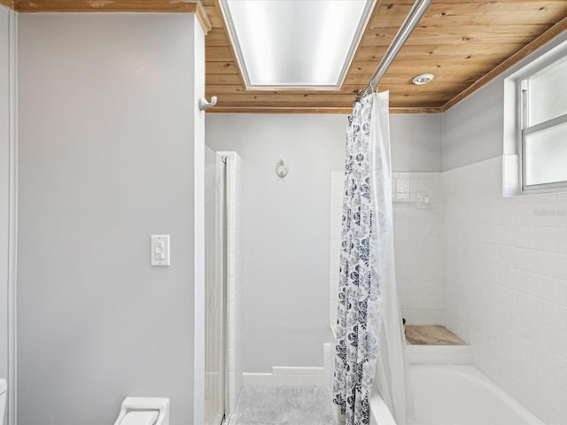 bathroom featuring toilet, wood ceiling, and shower / bath combo