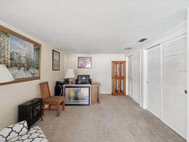 living area with visible vents and carpet flooring