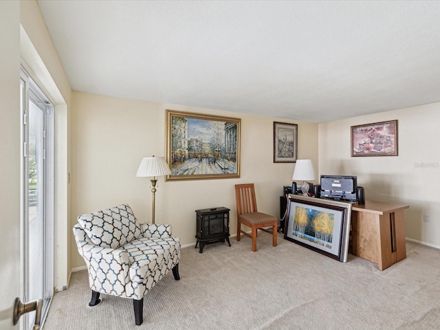 sitting room featuring light carpet and baseboards