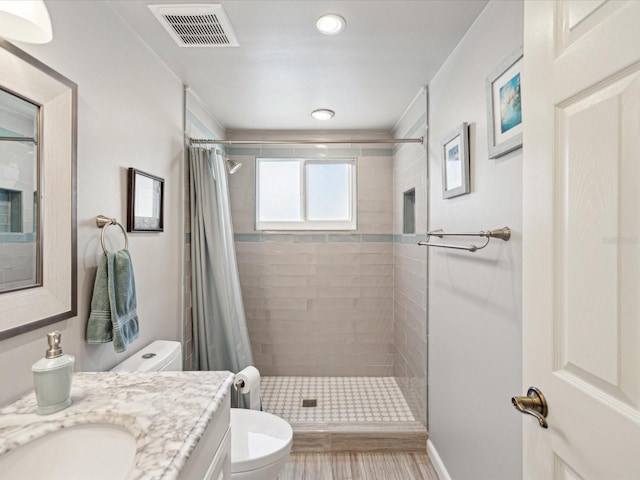 bathroom featuring a stall shower, visible vents, vanity, and toilet