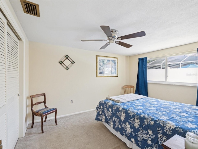 bedroom with visible vents, baseboards, a ceiling fan, carpet, and a closet