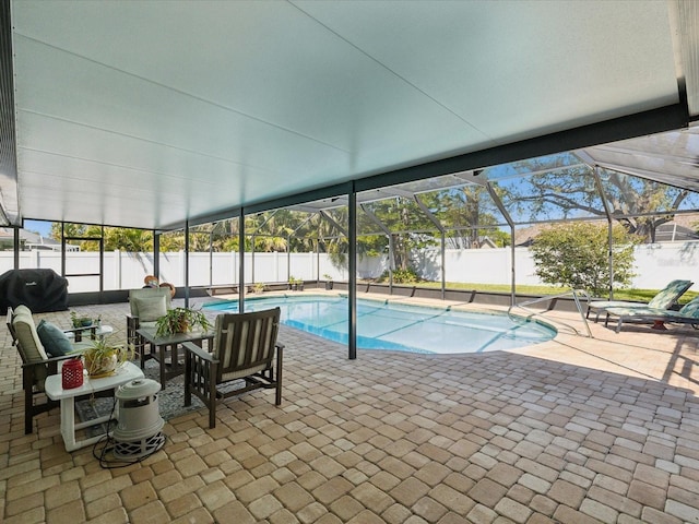 view of swimming pool with a patio, glass enclosure, a fenced backyard, and a fenced in pool