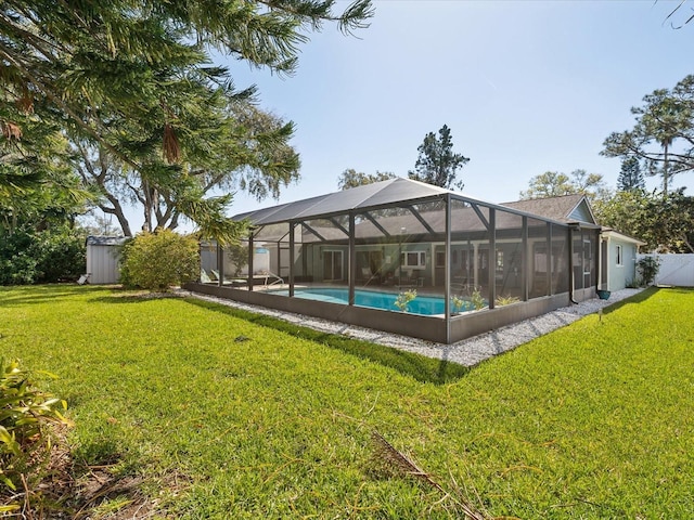 view of swimming pool featuring a lanai, fence, a fenced in pool, and a yard