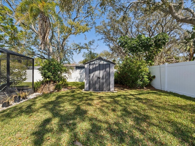 view of yard with an outbuilding, a fenced backyard, and a shed