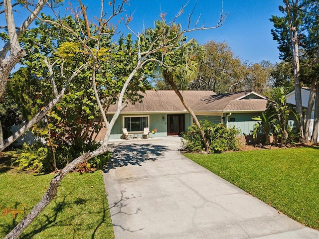 view of front of property featuring concrete driveway and a front lawn