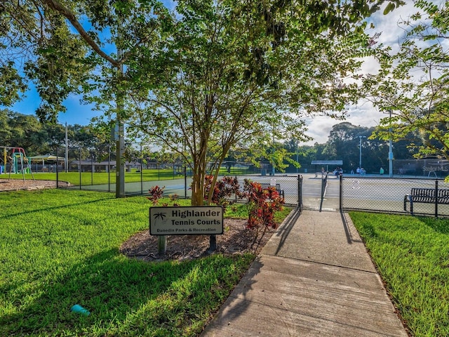 view of home's community with a gate, playground community, a yard, and fence