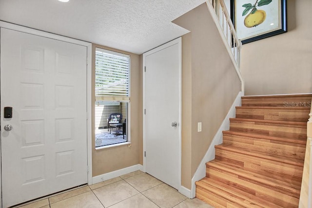 tiled foyer with a textured ceiling