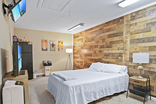 carpeted bedroom with wooden walls and a textured ceiling