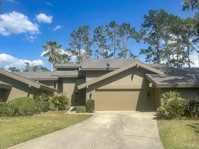 view of front of property with an attached garage, driveway, and a front lawn