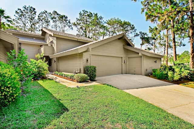 view of front of home with a garage, driveway, and a front yard