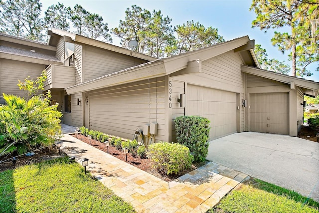 view of property exterior featuring an attached garage and driveway