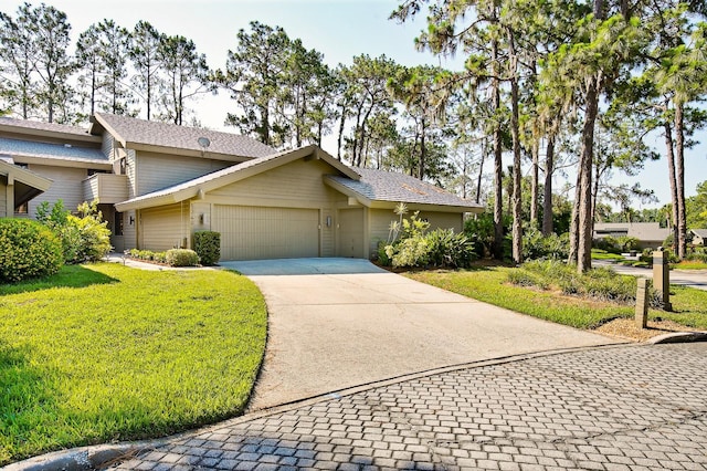 view of front facade featuring an attached garage, a front yard, and concrete driveway