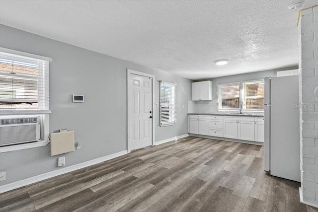 kitchen featuring sink, white cabinetry, white fridge, hardwood / wood-style floors, and decorative backsplash