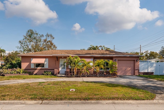 ranch-style house featuring a garage and a front yard