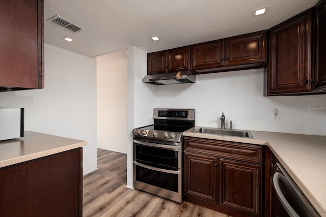 kitchen featuring dishwashing machine, dark brown cabinets, light wood-type flooring, and range with two ovens