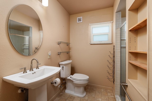 bathroom with toilet, an enclosed shower, and sink