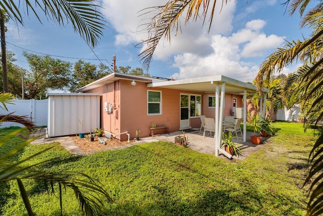 rear view of house with a yard and a patio area