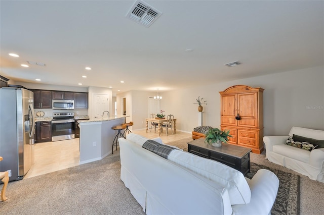 carpeted living room with sink and a chandelier