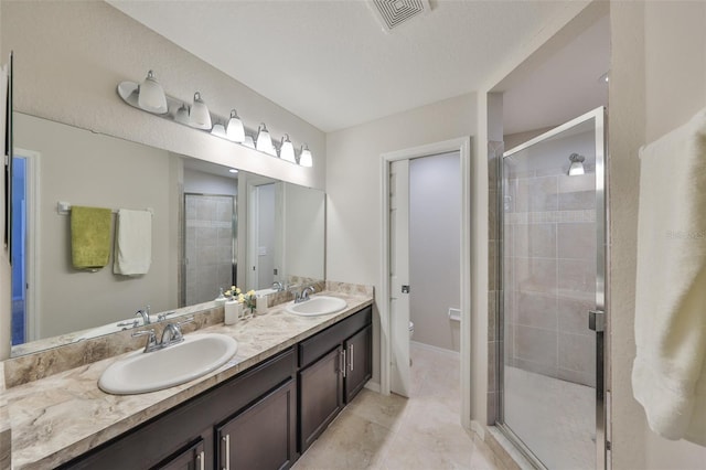 bathroom featuring vanity, tile patterned flooring, a shower with shower door, and toilet