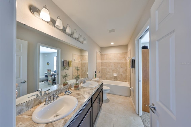 full bathroom featuring tile patterned flooring, tiled shower / bath, vanity, and toilet