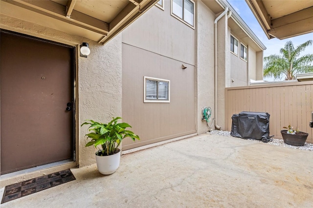 view of exterior entry with a patio