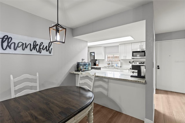 dining space with sink and light wood-type flooring