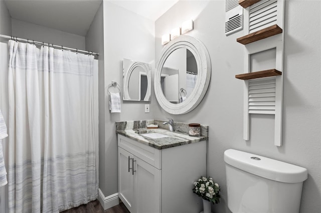 bathroom with hardwood / wood-style flooring, vanity, and toilet